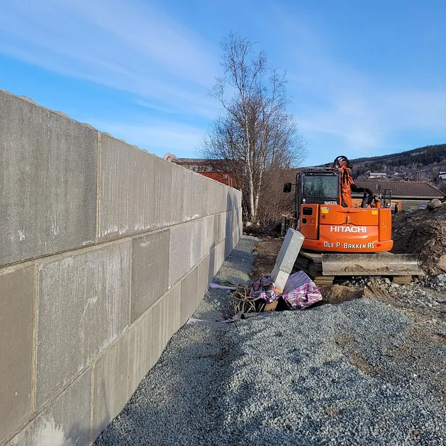 Betongmur og gravemaskin