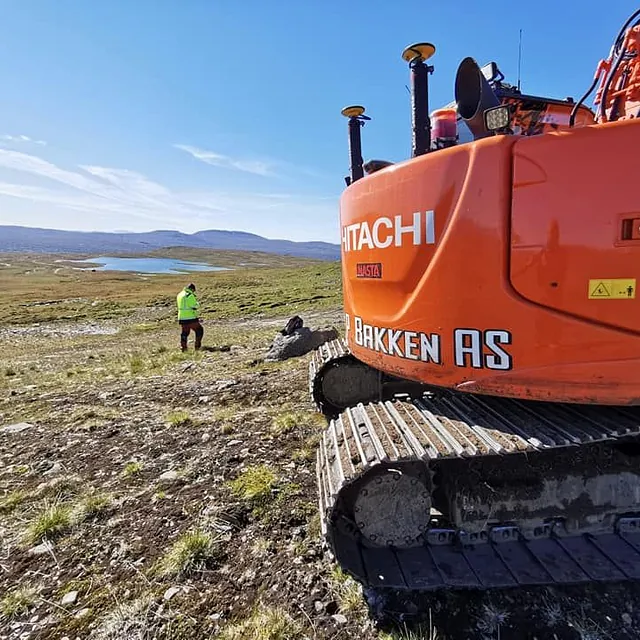 Gravemaskin i flatt fjellområde