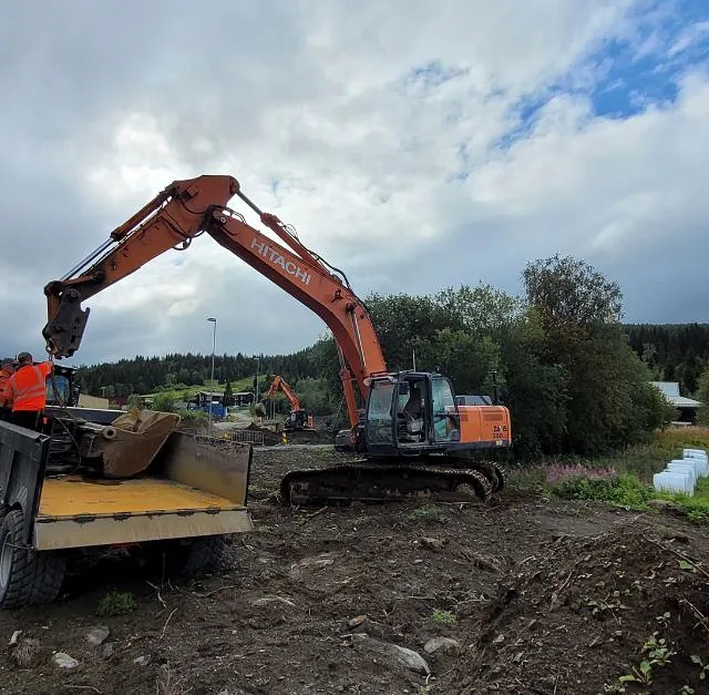 Gravemaskin og lastebil