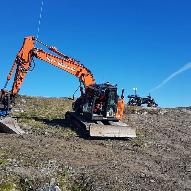 Gravemaskin parkert i fjellområde